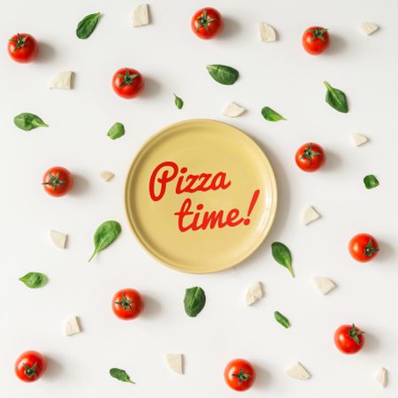 Basil, tomatoes, and cheese on light background with plate and “Pizza time!” text
