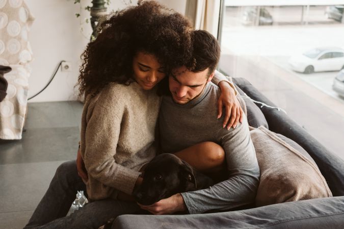 Multiethnic couple with dog on couch