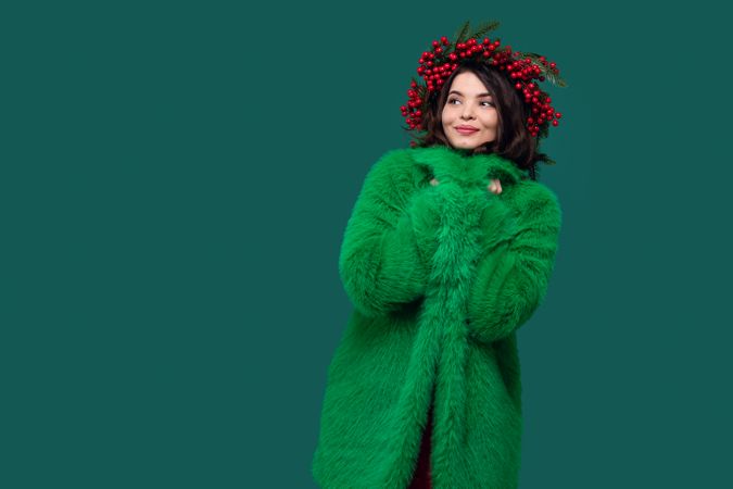 Woman in green coat and berry wreath