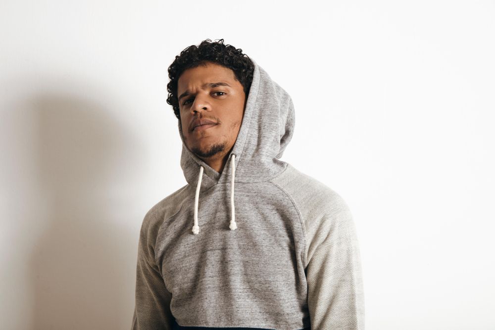 Man in grey hoodie looking at camera
