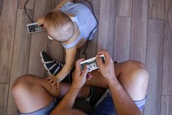 Anonymous father and baby playing video games