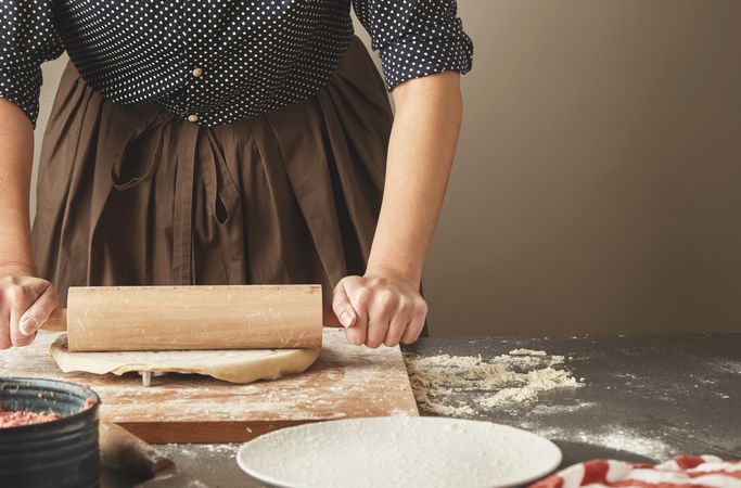 Woman rolling out dough in to circle