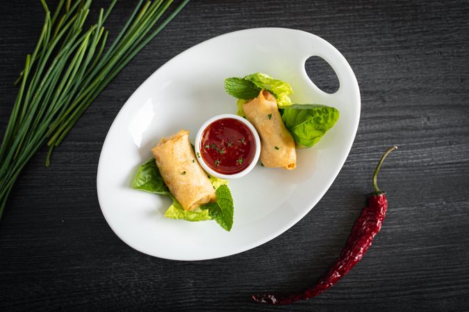 Vietnamese rolls with sweet chili on glass plate