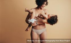 Happy woman carrying her child in her arms 4Z9k35