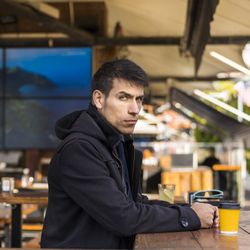 Handsome man looking seriously at camera after drinking a coffee