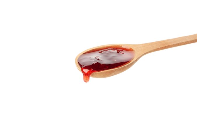 Spoon with strawberry jam isolated on plain background