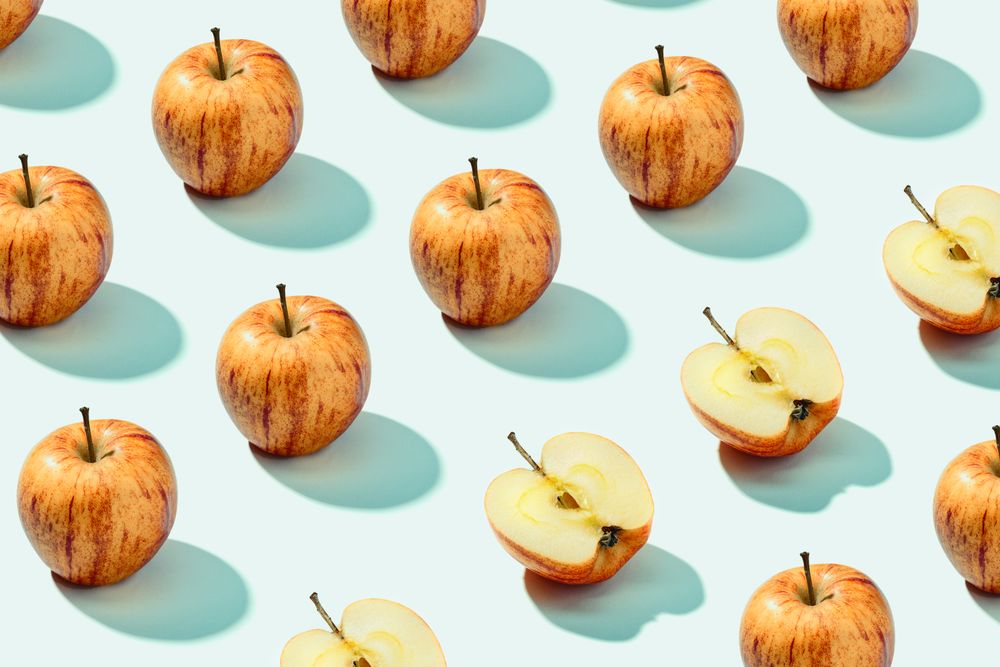 Half apple in row with whole apples