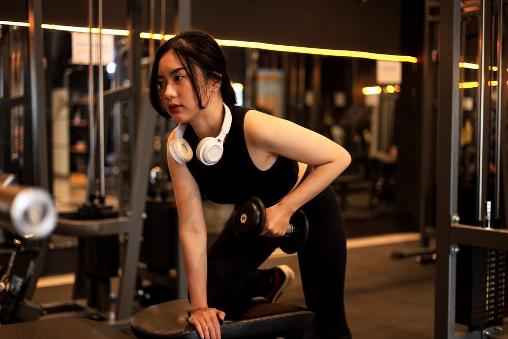 Young Woman Lifting Dumbbell in the Gym