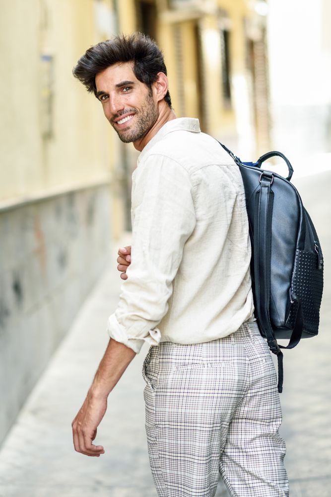 Young man looking back while walking through the streets of Granada