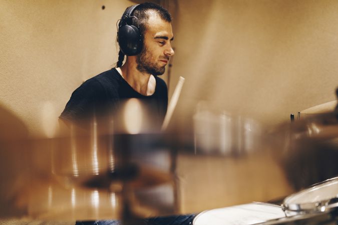 Man with headphones playing on drums