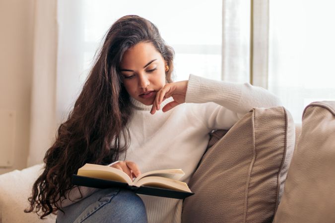Relaxing at Home: Young Woman Reading a Book