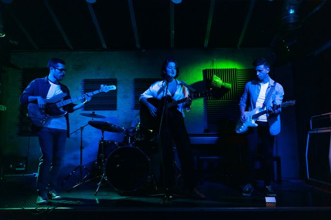 Musicians In Stage With Colorful Lights Performing In A Live Concert