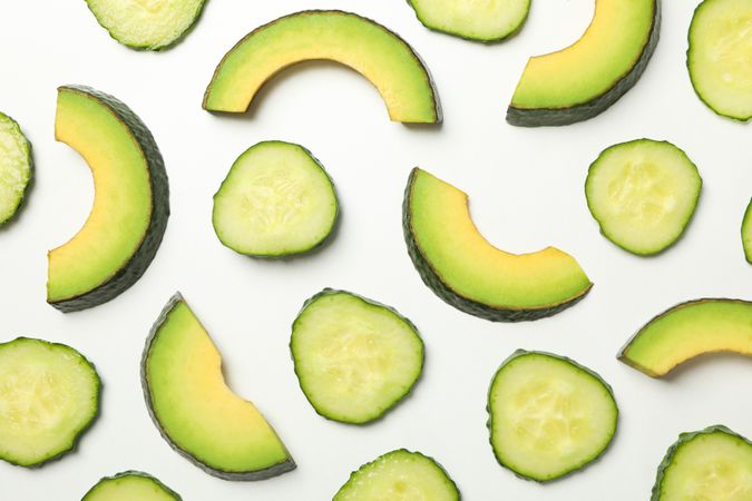 Flat lay with avocado and cucumber slices on blank background