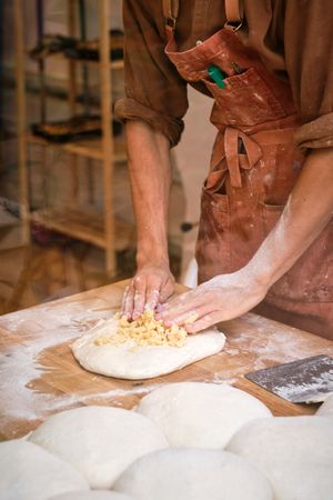 Young male baker preparing dough for bread making