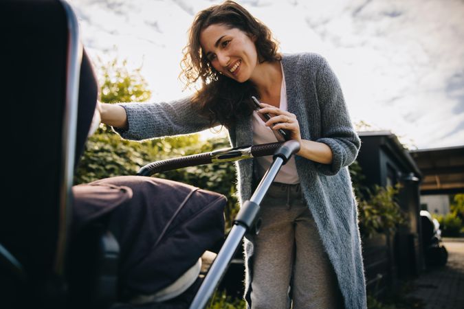 Smiling mother adoring her baby fastened in a stroller