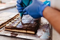 Crop confectioner decorating small cakes