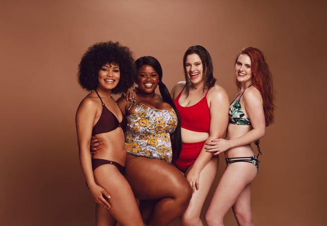 Diverse models in swimwear looking at camera and smiling