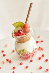 Delicious yogurt dessert with pomegranate, kiwi, grape and ginger biscuit