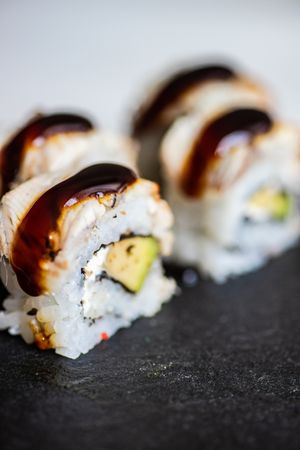 Close up of delicious sushi rolls with crab, avocado, eel sauce and cream cheese