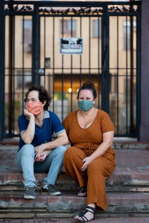 Married couple sitting and looking at neighborhood on outside stoop