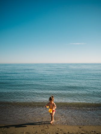Girl playing with little stones on beach