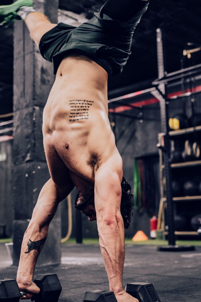 Strong flexible male doing exercise in sport club