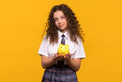 Girl holding a yellow piggy bank