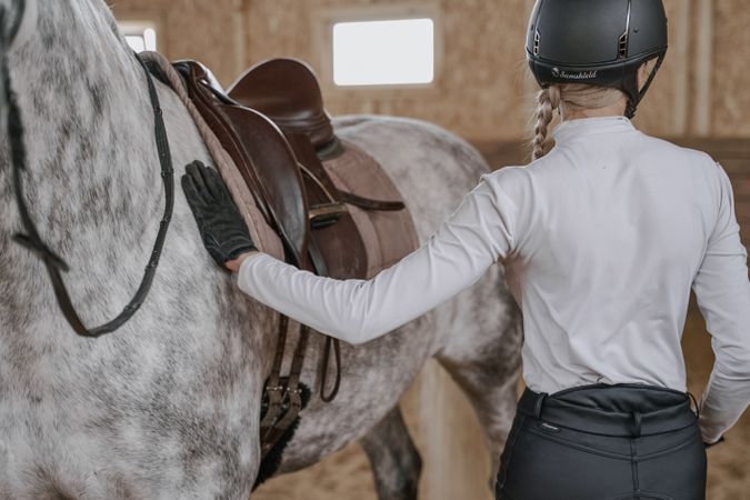 Rider with dapple gray horse in round arena