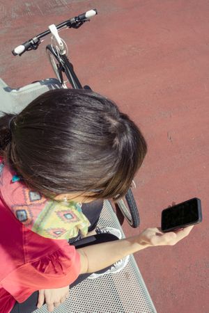 Sportive woman with fixie bike looking smartphone