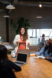 Woman smiling while talking to her colleagues in a modern open office