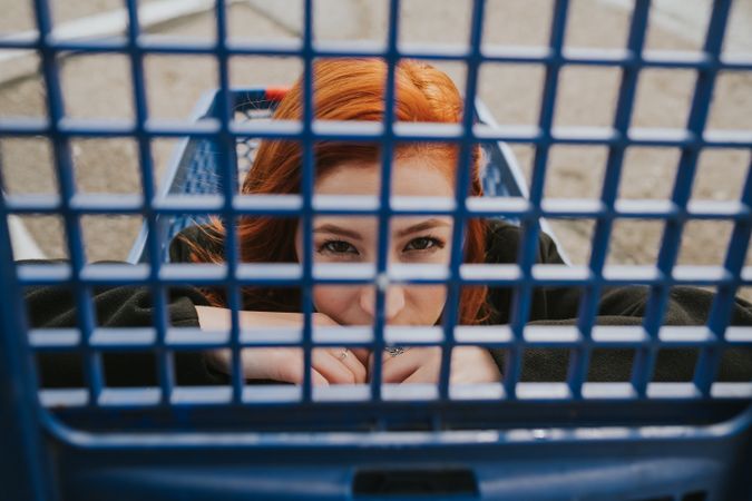 Woman looking through trolley grate in shopping cart