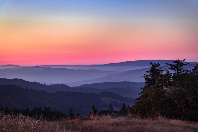 Beautiful colorful sunset over tree lined hills on the West Coast