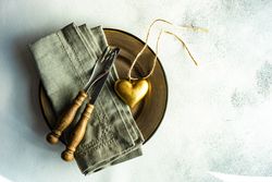 Top view of rustic table setting with heart decoration on marble table