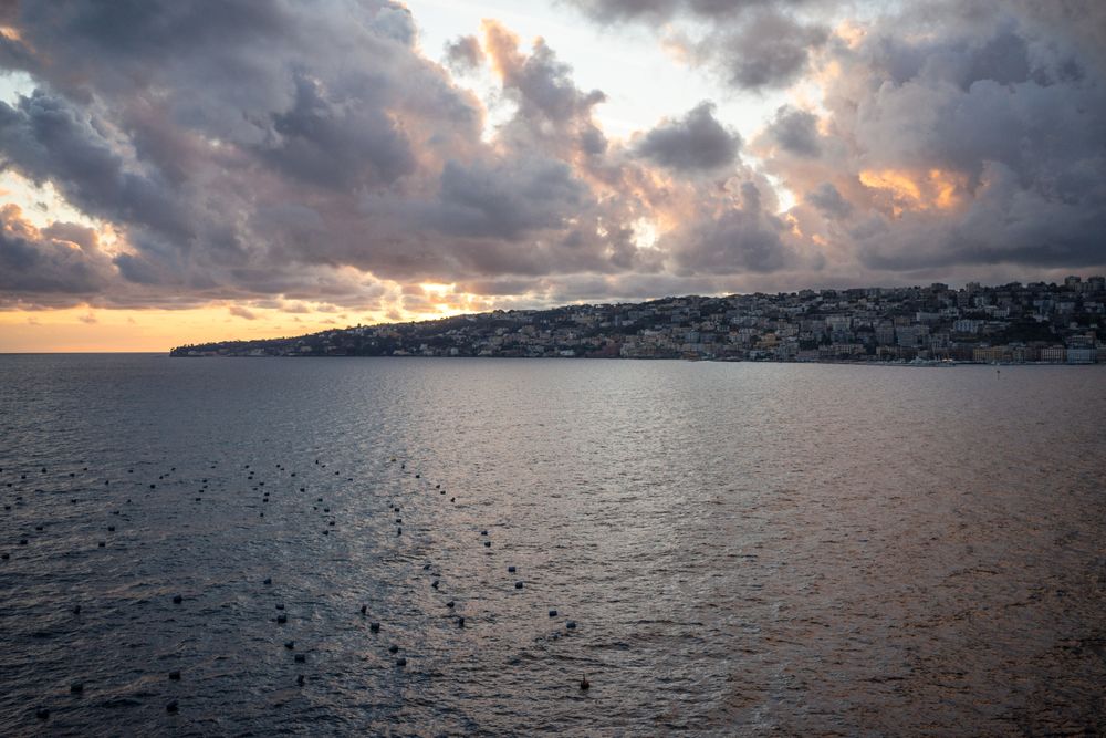 Landscape of calm sea and big city ob shore and beautiful cloudy sky