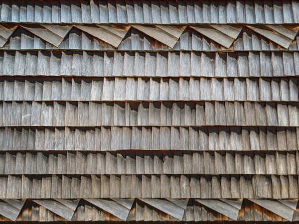 Weathered wood shingle-clad exterior wall of an Swiss chalet