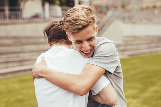 Two boys hugging each other in college campus