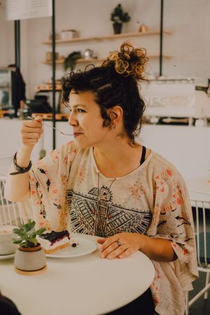 Delighted woman enjoying dessert in cafe