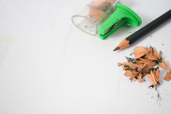 Pencil laying on table with shavings & sharpener with copy space