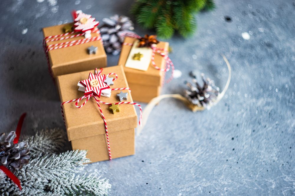 Three brown Christmas gifts with tree branch decorations