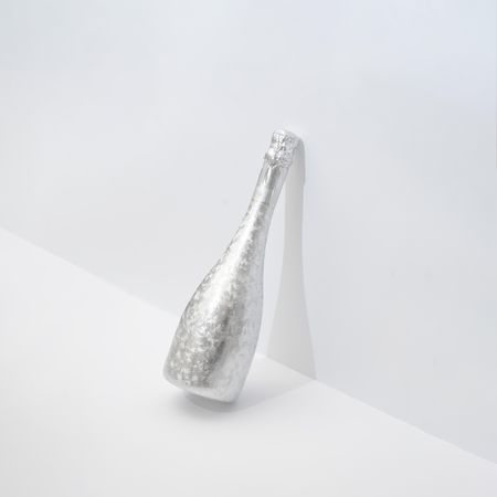 Silver champagne bottle leaning on  wall