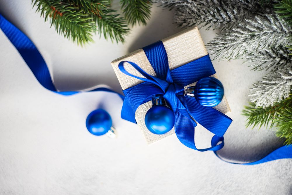 Top view of Christmas present with blue ribbon and baubles