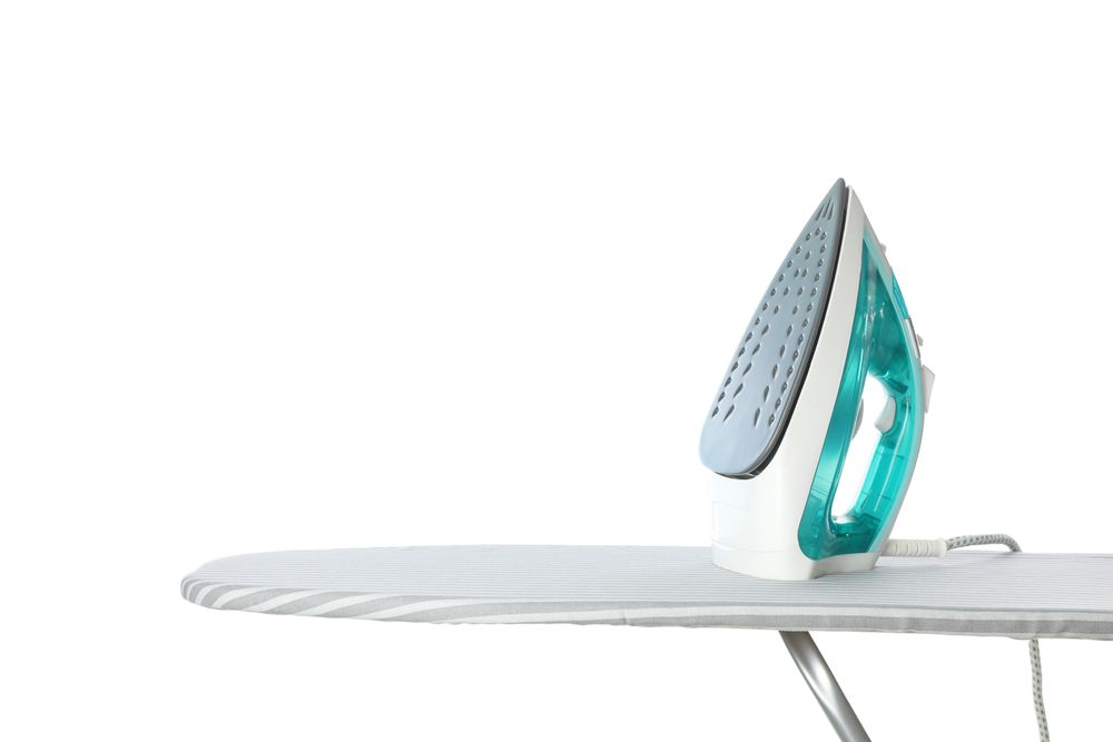 Iron on ironing board isolated on plain background