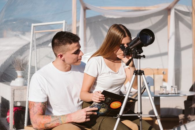 Young couple using astronomical telescope