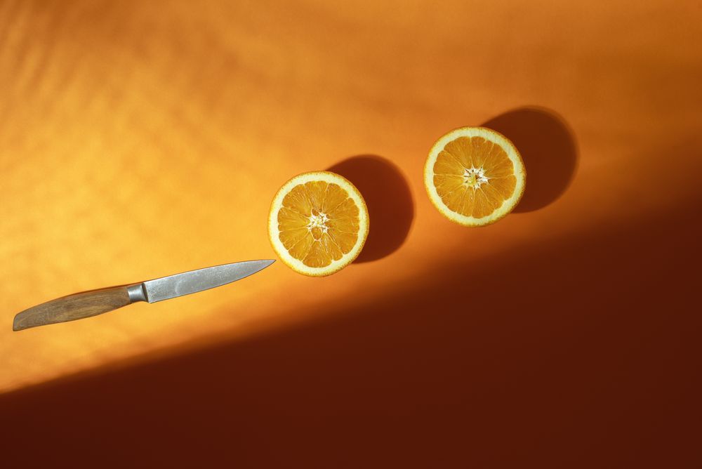 Sliced oranges with knife