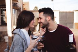Happy couple drinking wine on terrace