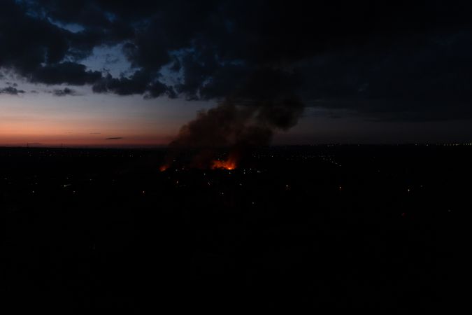 Massive fire burns at residential neighborhood under dark sky