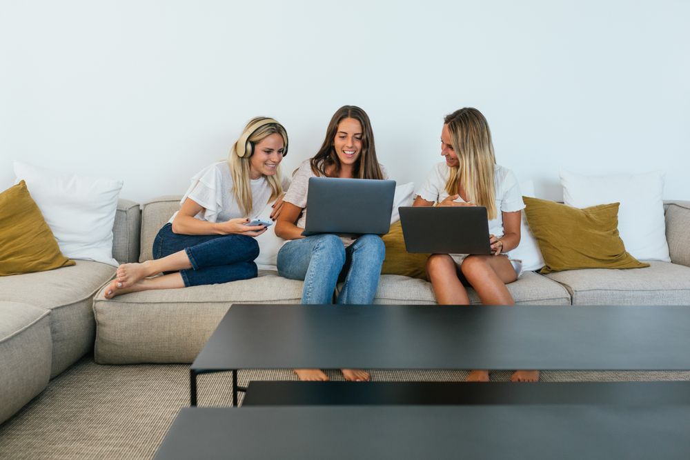 Woman showing her laptop screen to positive friends