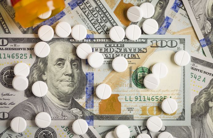 Medicine Pills Scattered on Newly Designed One Hundred Dollar Bills