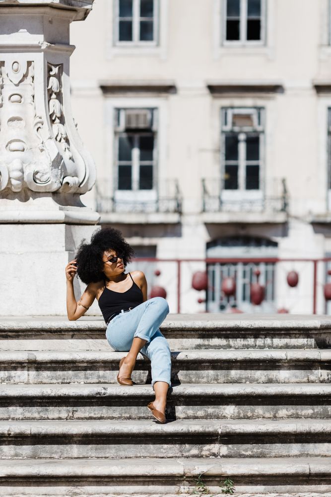 Black female sitting on stairs outdoors