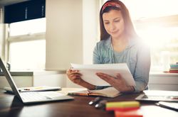 Woman reading notes at her desk